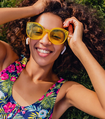 young-stylish-black-woman-listening-music-wireless-earphones-having-fun-lying-grass-park-s