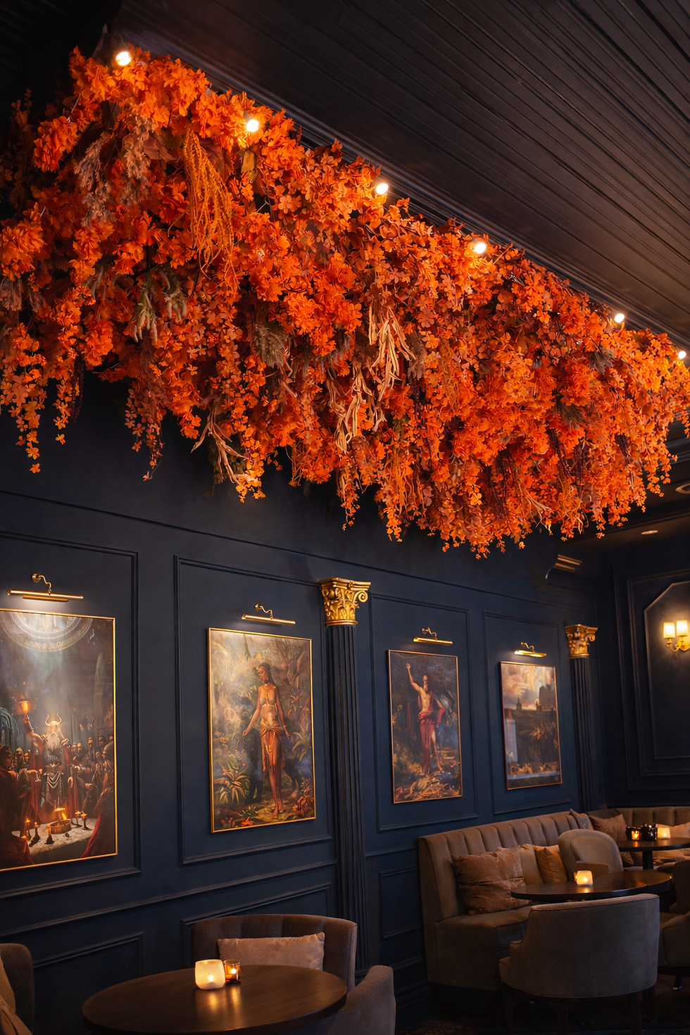 “Orange cascading artificial floral ceiling installation in a luxury restaurant lounge with dark blue walls and warm lighting