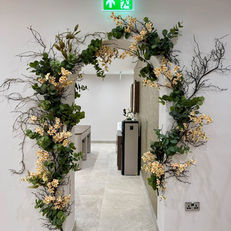 botanical greenery arch with peach flowers for salon installation