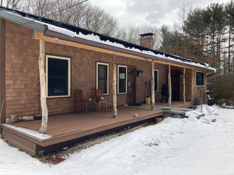 Eco-friendly front porch with Azek decking, cedar trunk supports, and stone stairs
