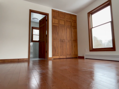 Master bedroom renovation with built-in storage, restored windows, and oak flooring