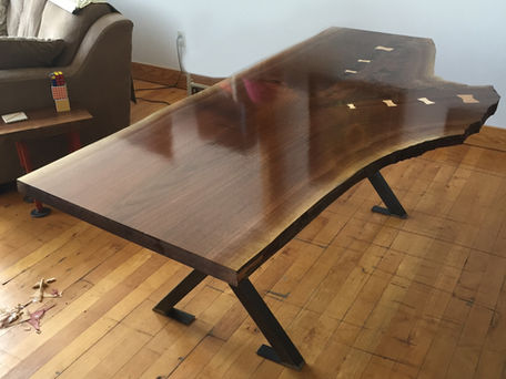 Live-edge dining table from a single tree slab with exotic wood inlays