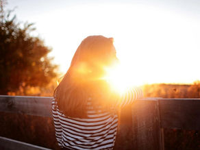Woman looking at bright sun set