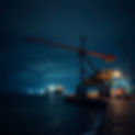 night shot of a mobile crane working by loading docks. show some of the ocean.jpg