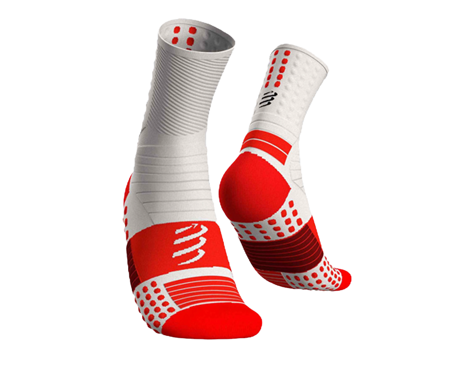 White and red socks with a textured pattern, featuring a logo and dots. Displayed against a black background, the design is sporty and vibrant.