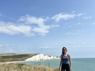 Charlotte Mann, with the White Cliffs of Dover in the background. She's wearing a blue running vest and black shorts.