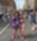 Andrea Watt and daughter Rebecca in purple race gear pose on a busy London street near Nelson's Column, after the London Marathon with their finisher medals