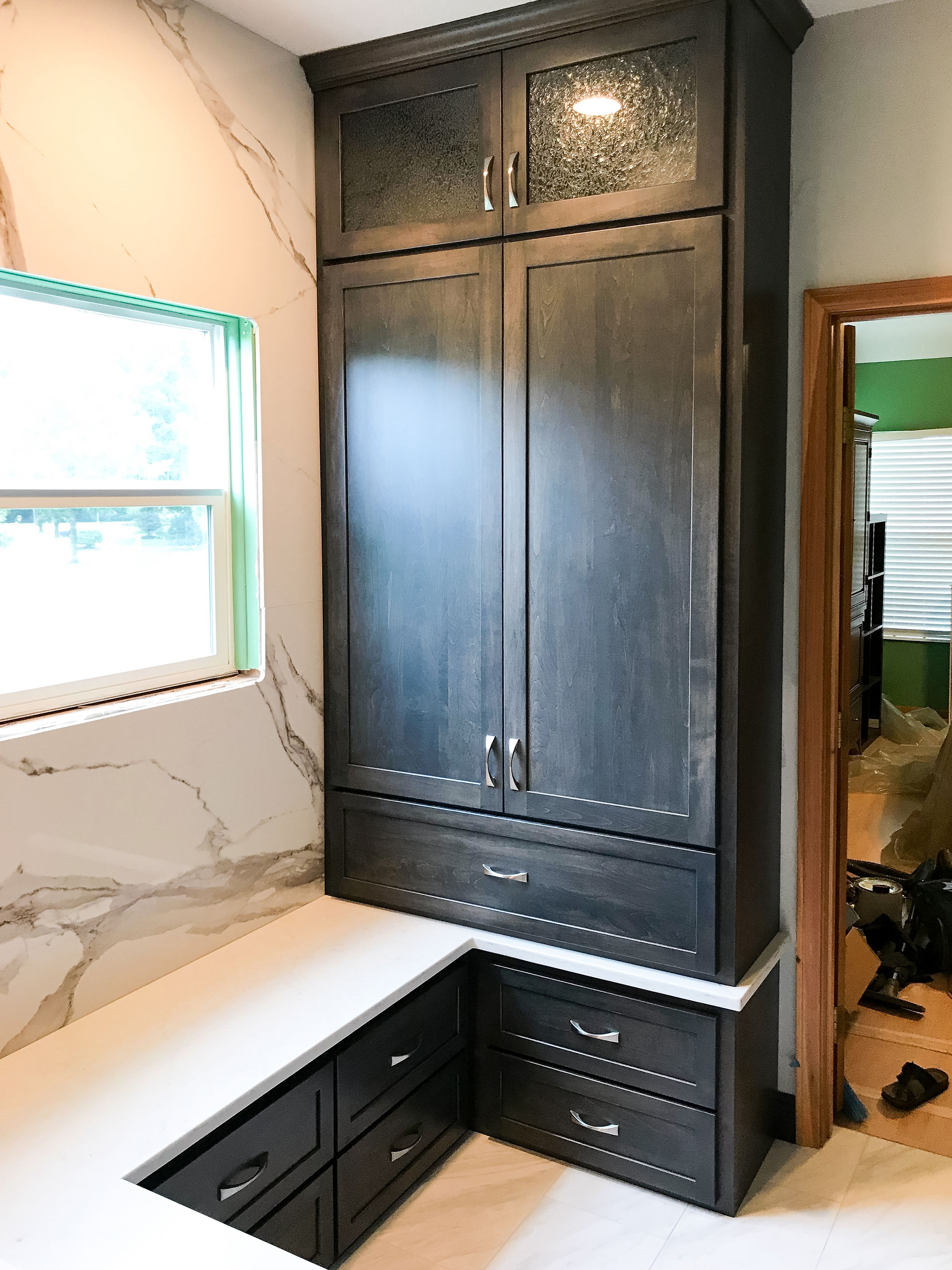 Builtin espresso stained cabinetry and quartz top replace the old fiberglass tub