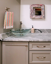 Built in vanity has three drawers and one door next to stacked washer/dryer combo