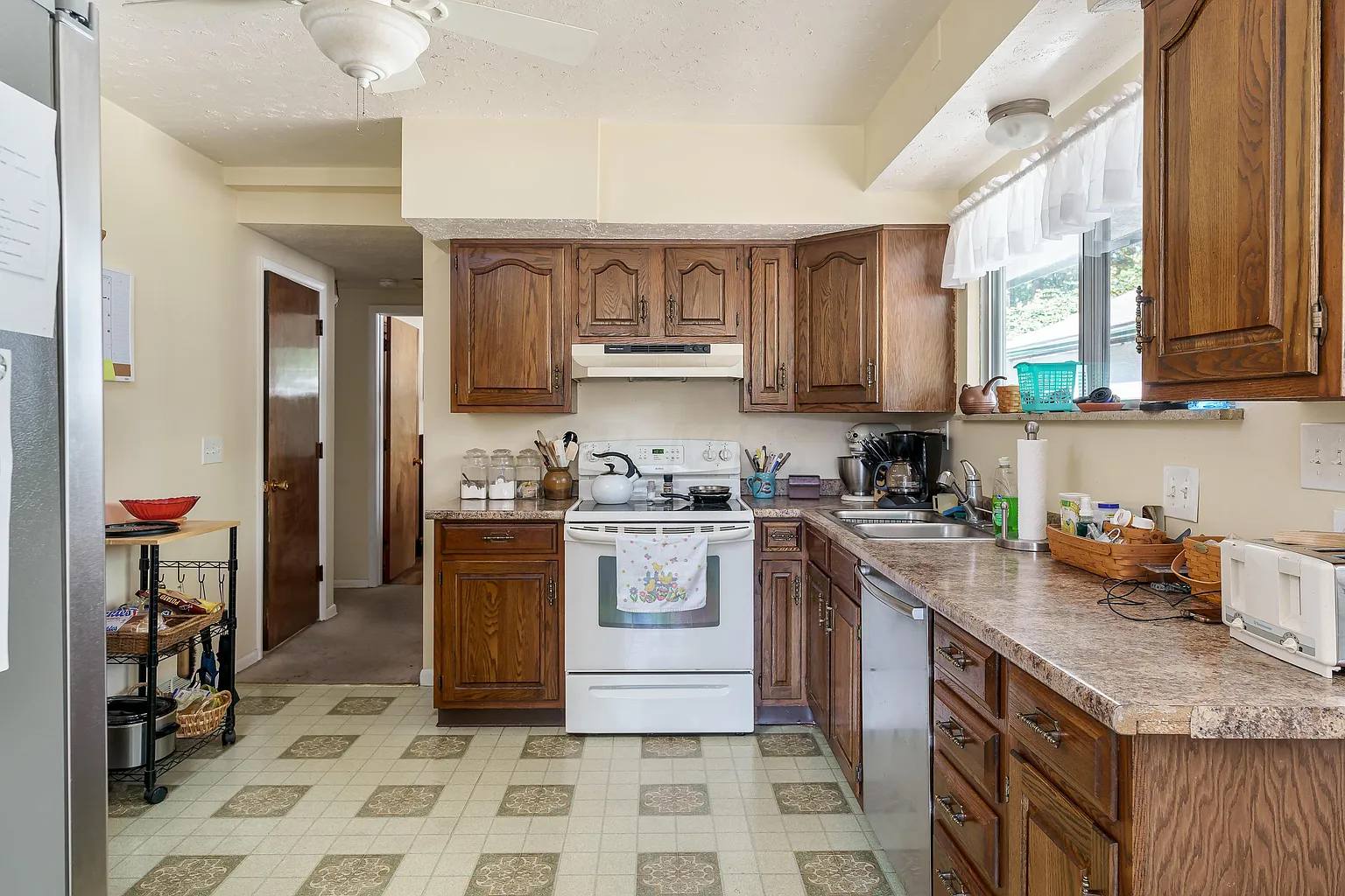 Kitchen with 80's soffit, linoleum flooring, and cracked countertop