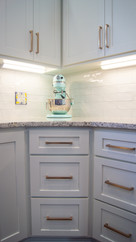 Corner cabinet with three drawers and upper cabinets with under mount lights