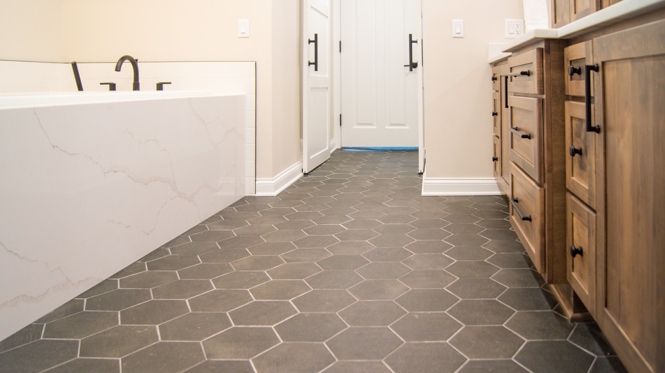 Large scale hexagon ceramic tile floor in ensuite of Rooms With A CBUS View by Barrett Home Renovations