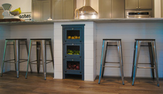 White painted shiplap covers custom center island with antique vegetable bin inlayed in center of island