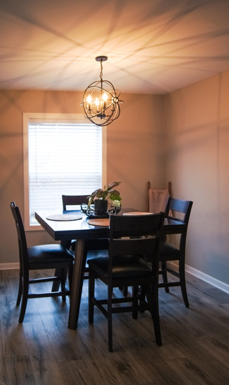 Wrought iron open globe chandelier centered above dining table