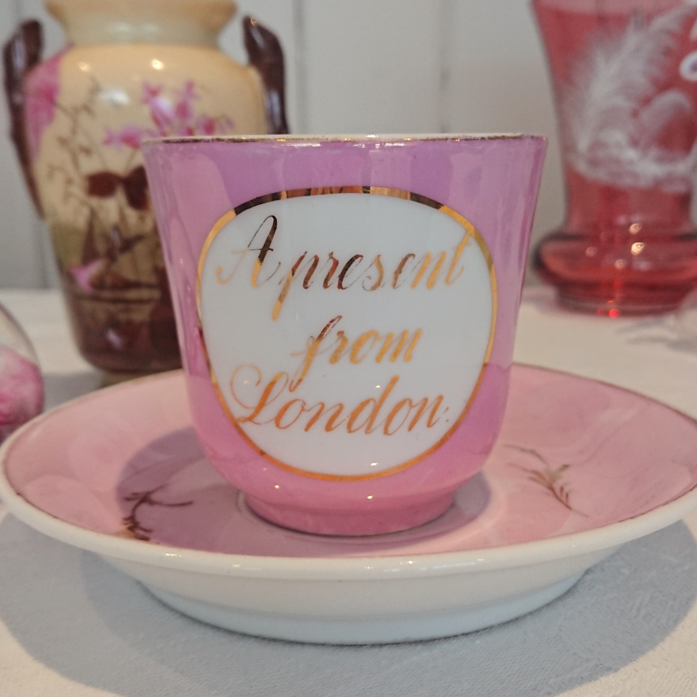 'A present from London' Victorian or Edwardian pink lustre teacup and saucer