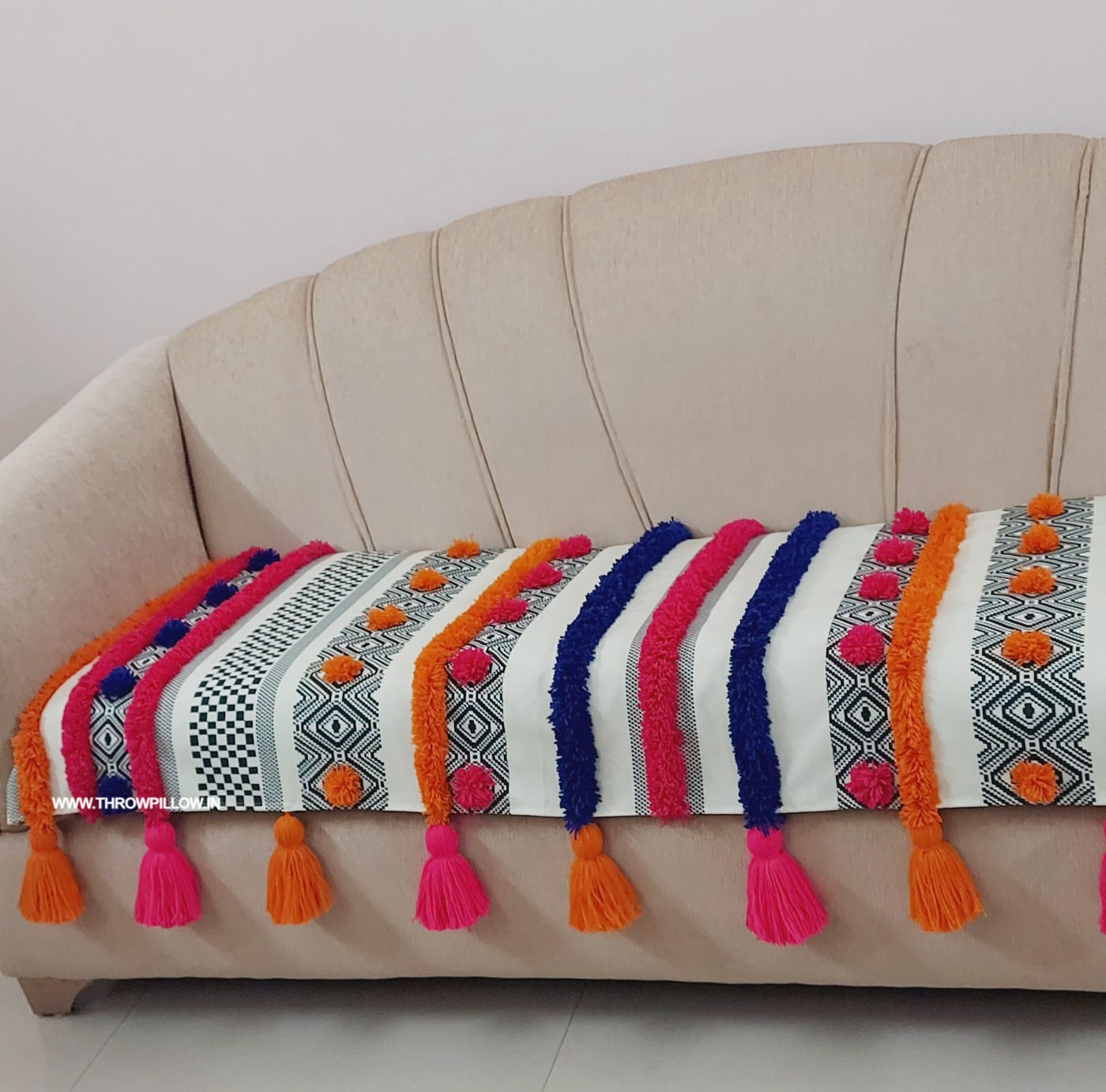 "Customized sofa cover with a colorful bohemian design and fun tassel accents"