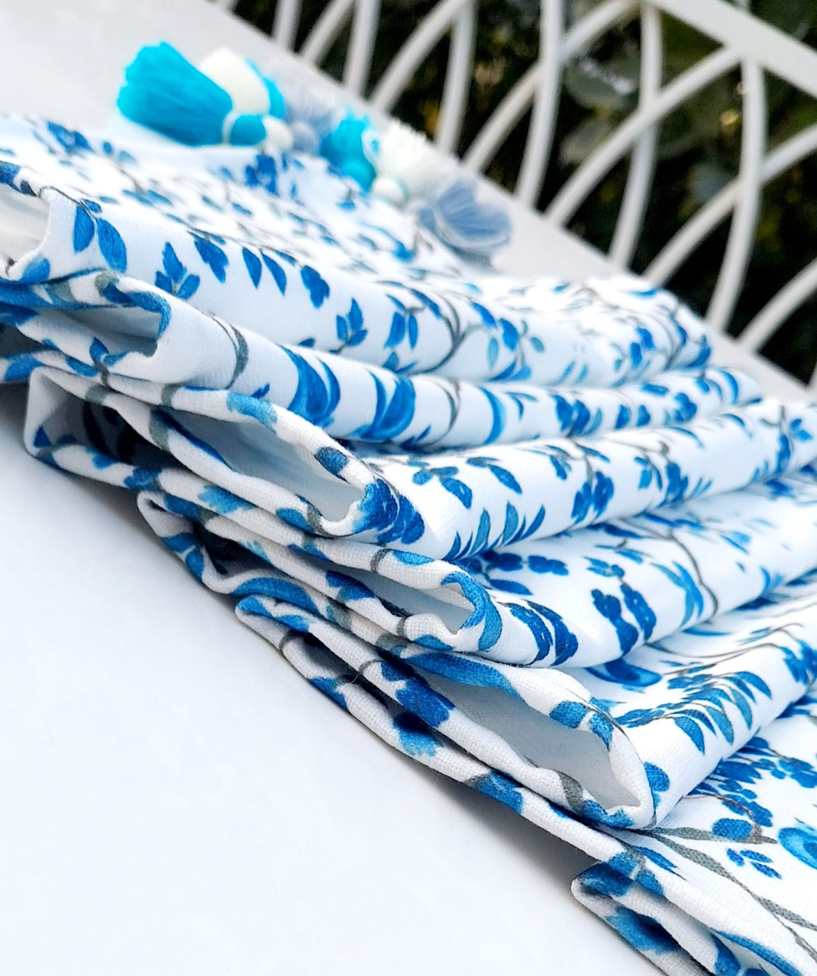 Designer white table runner with blue tassels and intricate bird print.