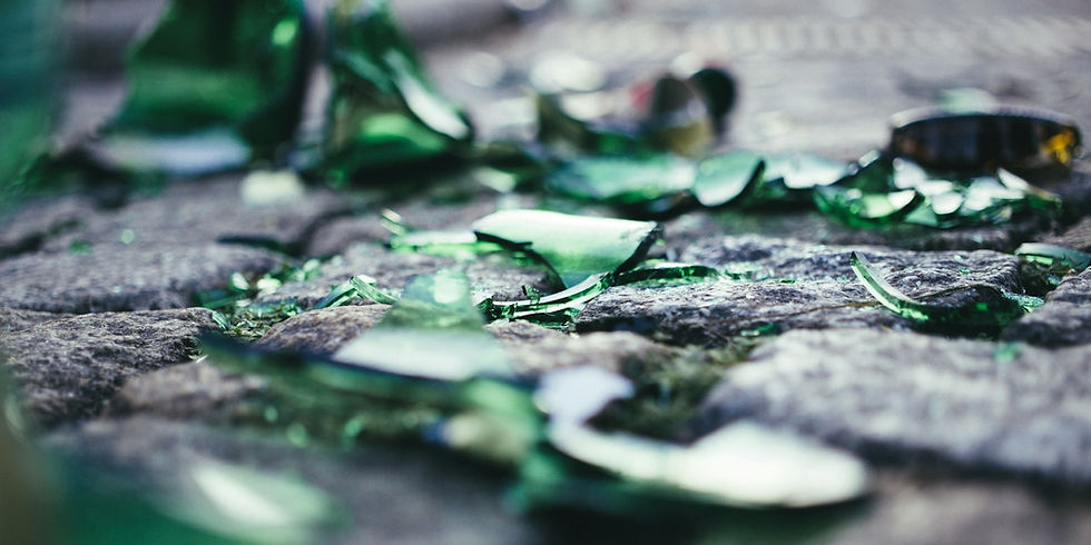 Fragments of broken green bottle lying on the ground