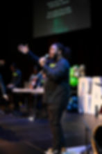 Worship leader singing on stage at Rapha Church
