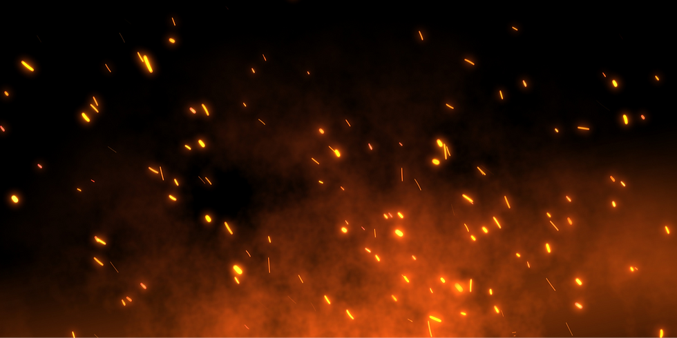 Bright, glowing embers lifting over a dark sky
