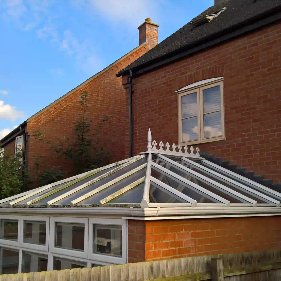 A dramatic comparison shot of a conservatory roof halfway through cleaning.