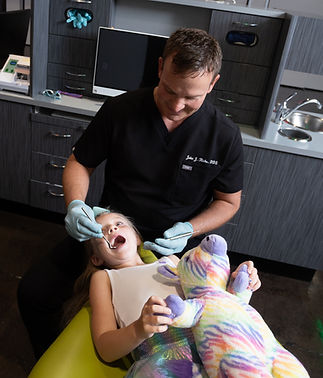 Dentist examining young girl's teeth