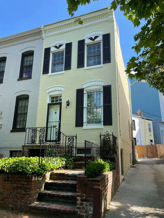 The sidewalk view of house and alley with tier of brick steps and a retaining wall.(D. Vogt, May 2022)