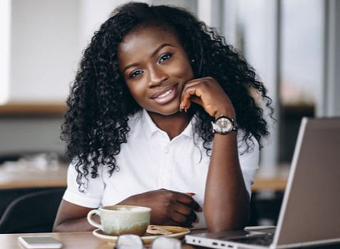 young woman sitting at a desk with a laptop.