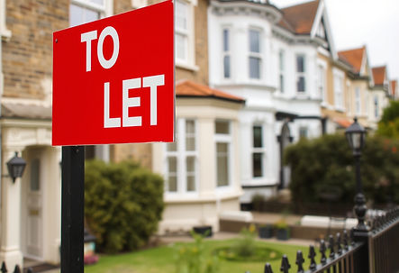 Red "TO LET" sign in front of row of suburban houses with white windows and gardens, creating a welcoming atmosphere.