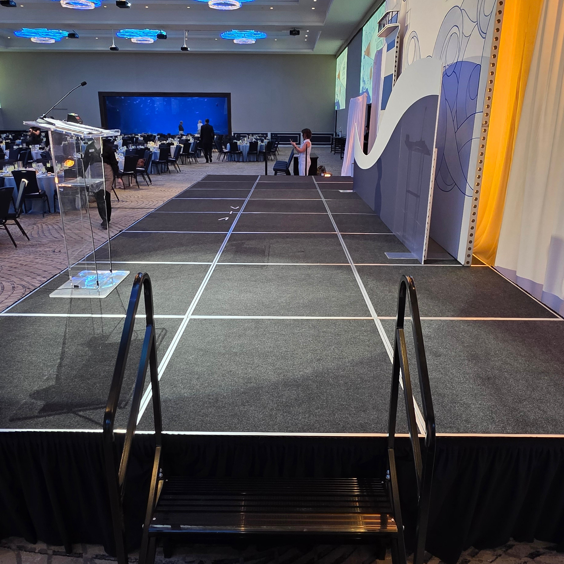 Compact live music stage setup with audio equipment, instruments, and stage lighting for a corporate event or reception in Utah at the Loveland Living Planet Aquarium.