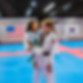 A Jeong's Taekwondo female instructor holds a young girl who is a student at Jeong's Taekwondo.
