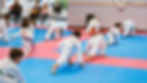 Several children stretch to start a group class at Jeong's Taekwondo Martial Arts.