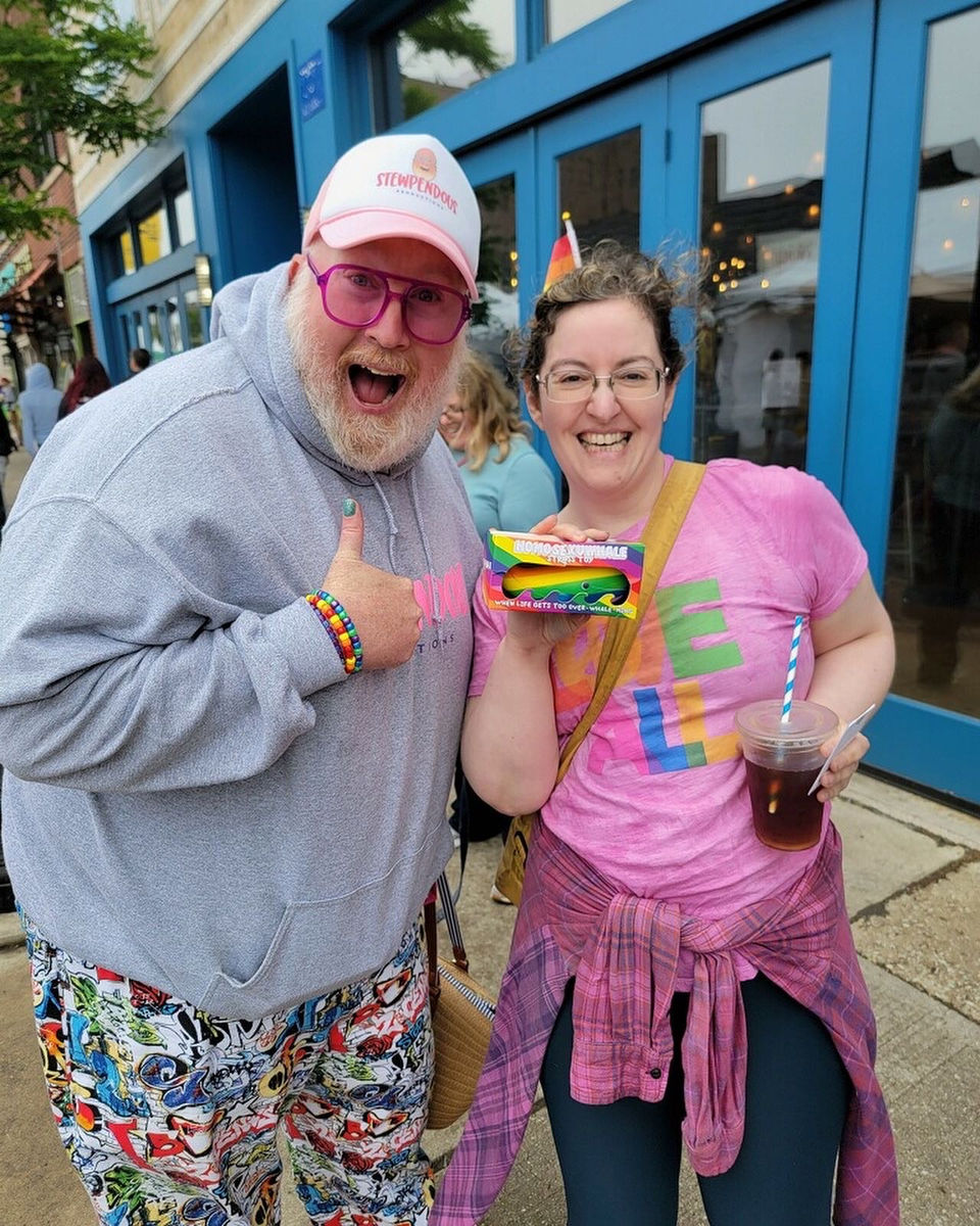 Lead Facilitator Stew posing with a Festival attendee who is holding a trivia prize