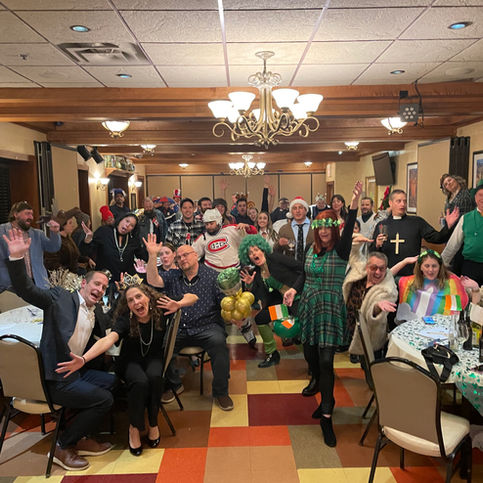 A big room with a bunch of Fundraiser attendees dressed for a St. Patricks day party