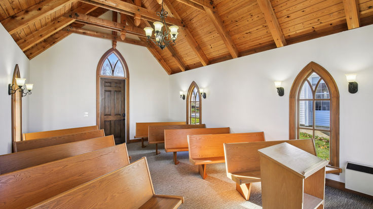 Interior of Little Shawnee Chapel with wooden pews and warm lighting