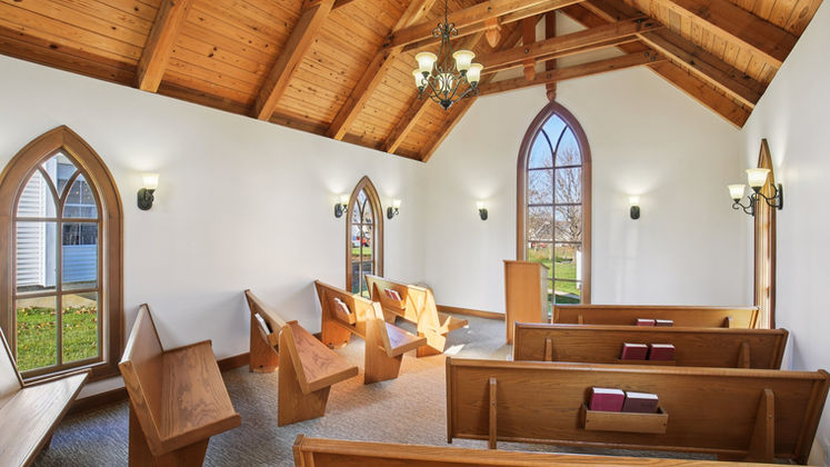Chapel interior with wooden pew seating and altar