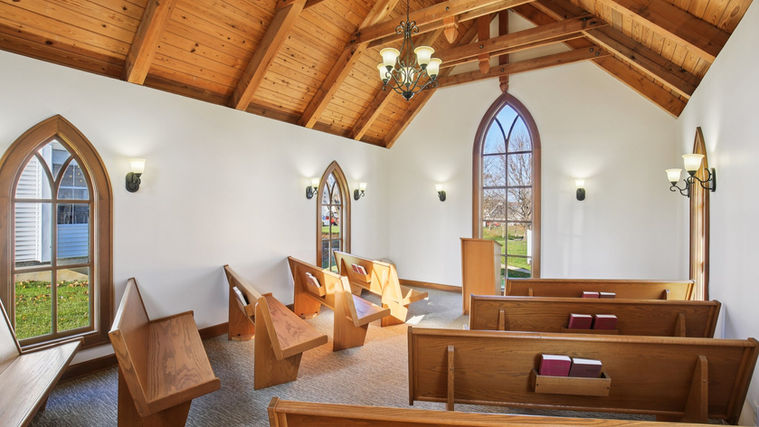 Chapel interior with wooden pew seating and altar