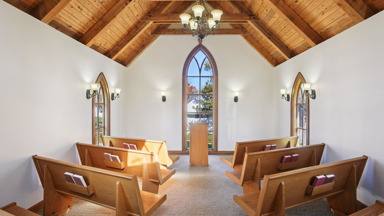 Interior of Little Shawnee Chapel with wooden pews and warm lighting