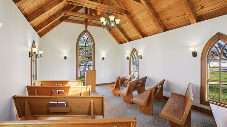 Interior of Little Shawnee Chapel with wooden pews and warm lighting