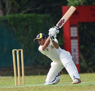 A man hitting a cricket ball.
