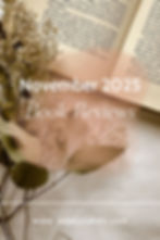 Open book with text, flowers in foreground. Text: "November 2025 Book Reviews" and "www.ashleycakes.com." Warm, vintage tone.