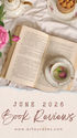 Open book with teacup, cake, and pink flowers on white linen; text reads June 2026 Book Reviews, www.asheycakes.com