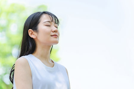 新緑の中で目を休める女性