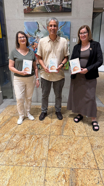 ענת דור, שושנה ויג ויהורם גלילי עומדים בתערוכה בבית חיל האורי בהרצליה עם ספרה של ענת דור "הנשיקה של הספר"