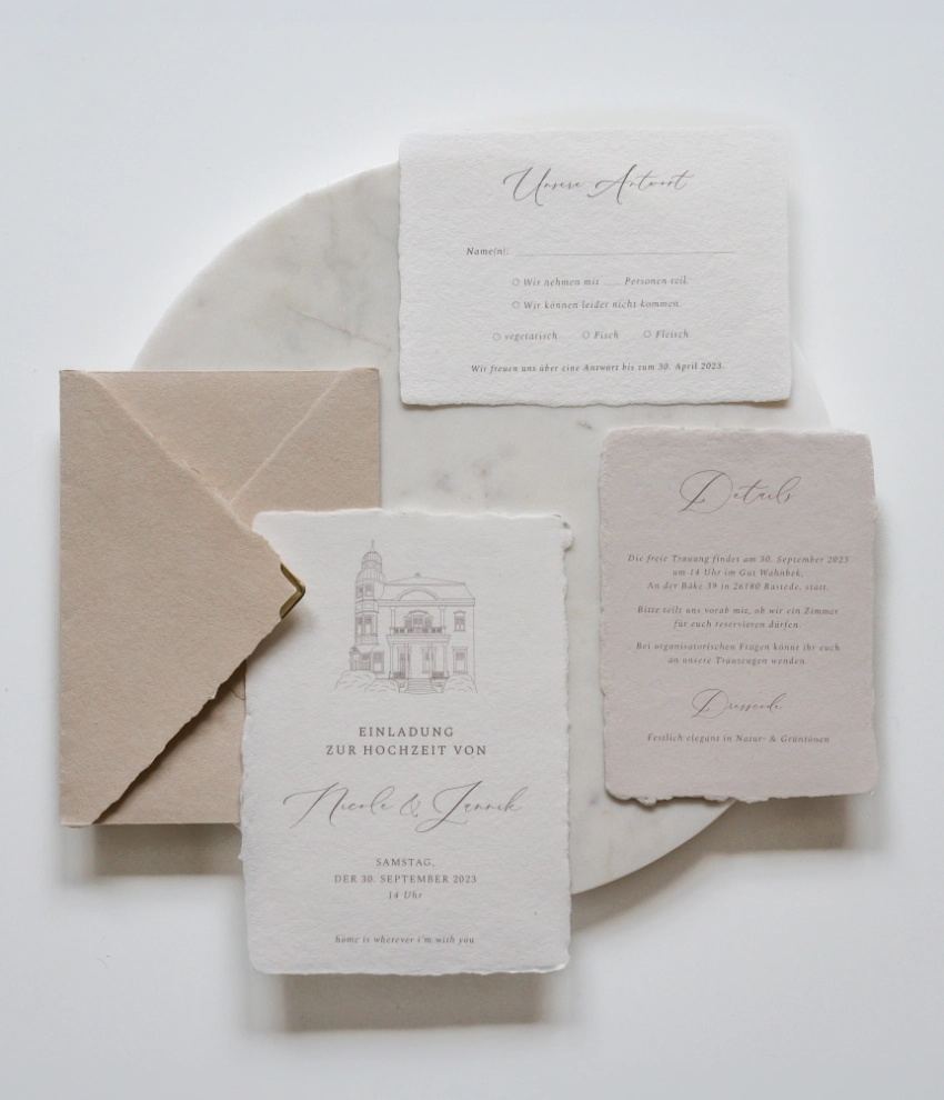 luxuriöse Hochzeitseinladung mit einzigartiger Locationzeichnung und Kalligrafieschrift in weiß und greige sowie sandfarbener Briefumschlag mit goldener Spitze für eine Hochzeit in der Toskana
