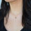 Thumbnail: model wearing rose cut diamond charm in 14k solid gold on thin gold chain