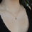Thumbnail: model wearing a rose cut diamond charm in 14k gold on a thin gold chain