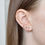 Thumbnail: model wearing stack of gold and gemstone earrings
