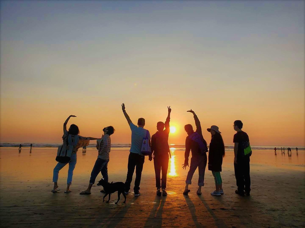 People are standing in front of the beach sunset