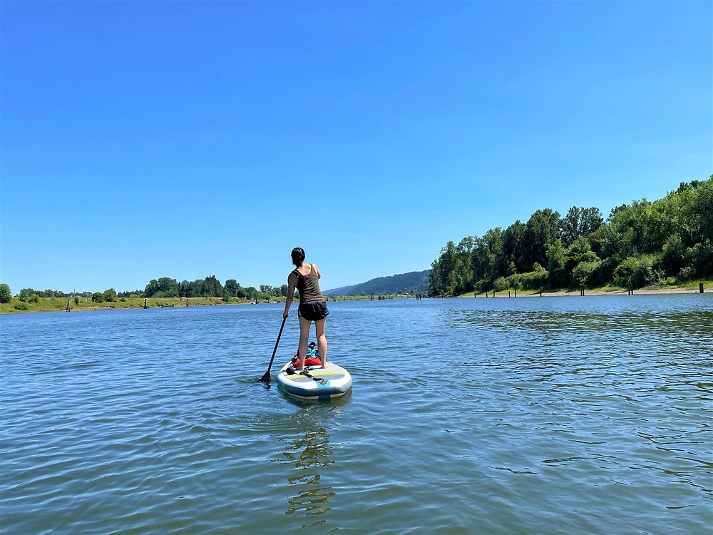 A woman is standing on the paddle board